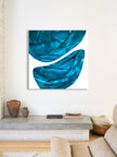 Blue abstract painting on a white wall above a console table in a living room.