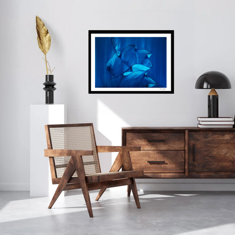 Abstract art print by London artist Lara Sayegh,. Blue ocean wave art print framed on wall in modern minimalist living room with wooden chair