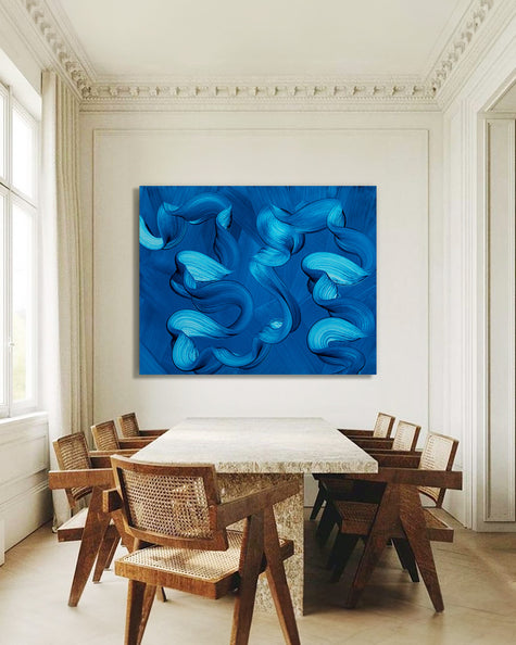 Dining room with a large blue ocean abstract painting on the wall above a marble table.