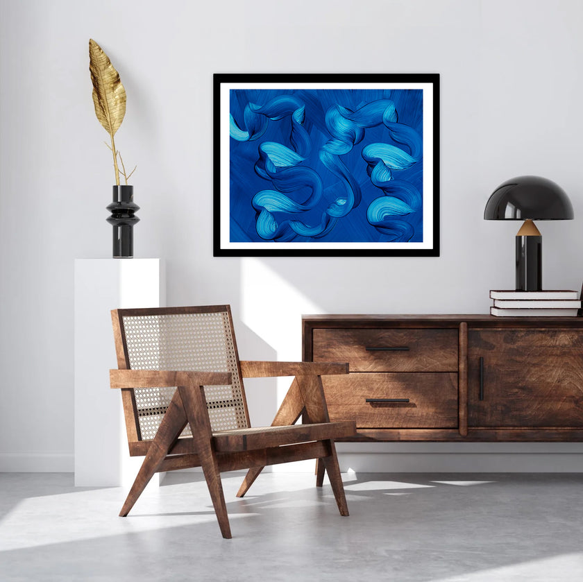 Modern living room with wooden armchair, sideboard, and abstract ocean blue art print on the wall.
