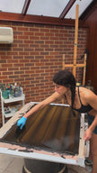 Artist Lara Sayegh creating an abstract oil painting on aluminium using rich earthy brown tones and layered gestural textures in her London studio.