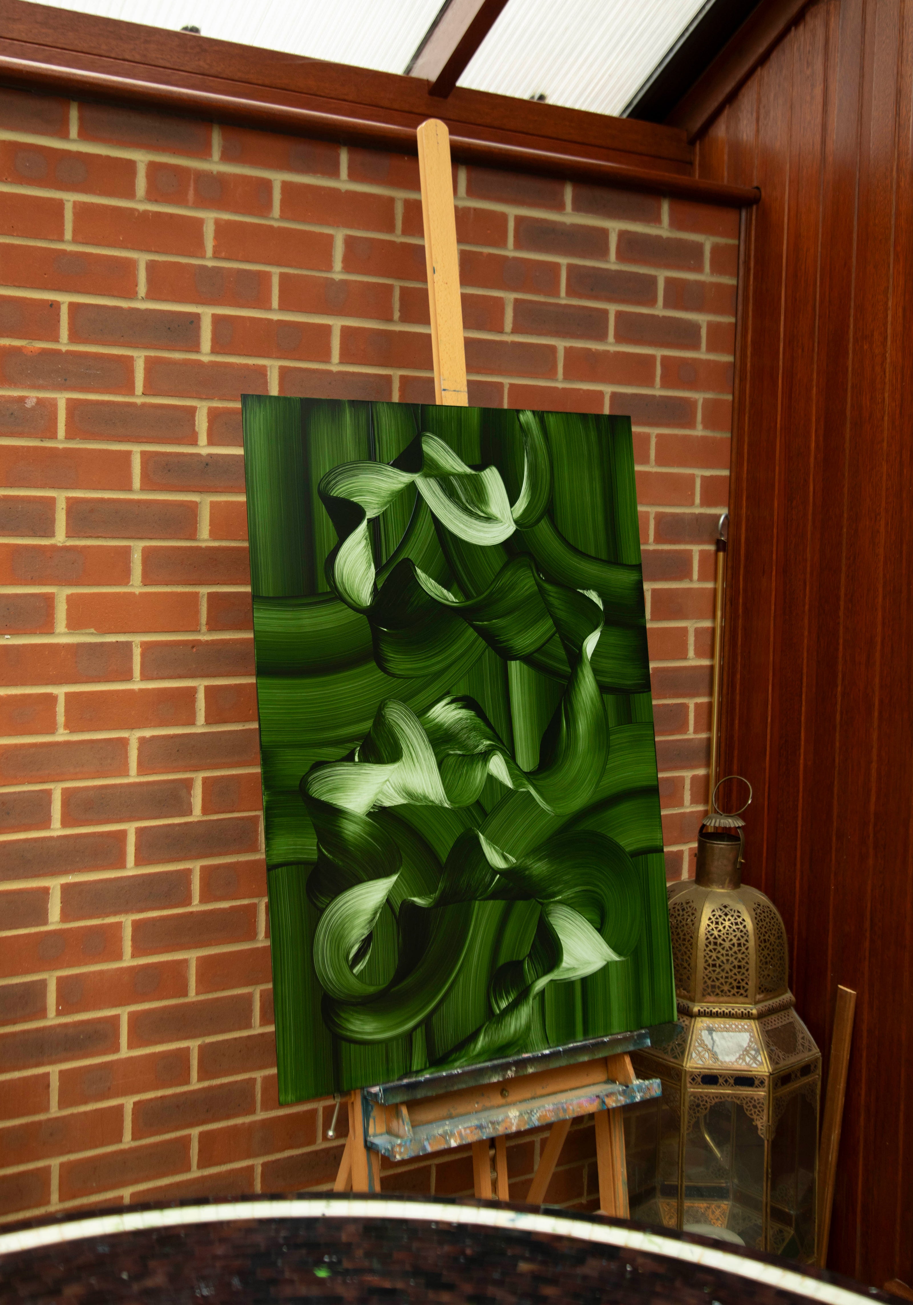 Close-up detail of contemporary green abstract oil painting with flowing ribbon-like brushstrokes and organic ocean-inspired movement