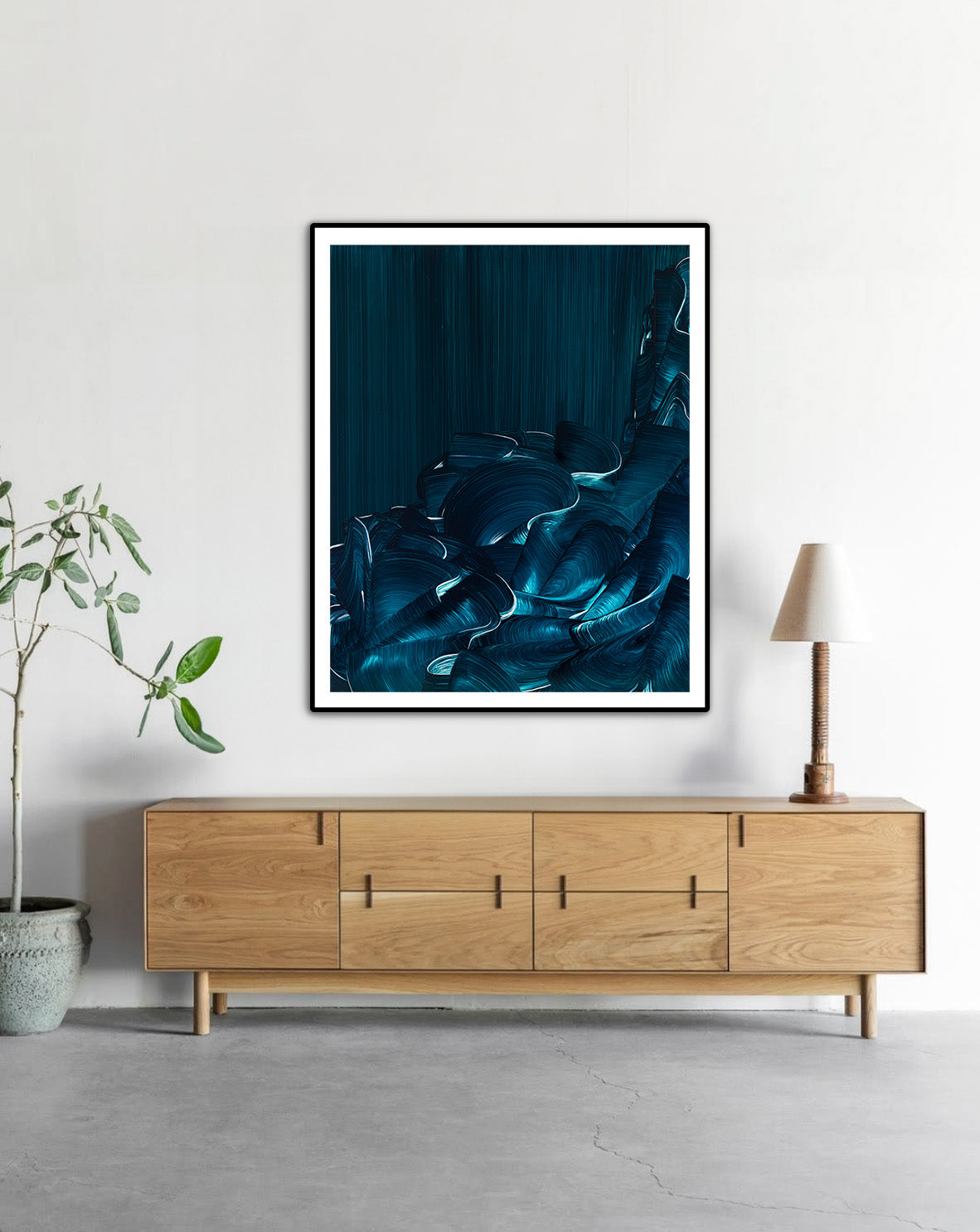 Tranquil Tide by Lara Sayegh displayed in a black frame, an abstract ocean wall art print with expressive blue brushstrokes, printed on museum-quality Giclée Fine Art Paper.